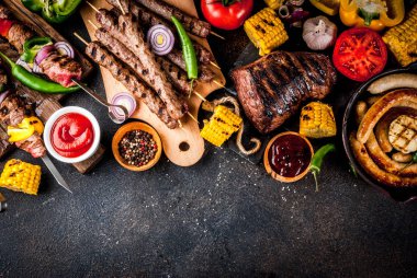Çeşitler çeşitli barbekü yemek ızgara et, Barbekü partisi fest - şiş kebap, sosis, ızgara et fileto, taze sebze, sos, baharat, karanlık paslı beton, yukarıdaki tabloda kopya alanı