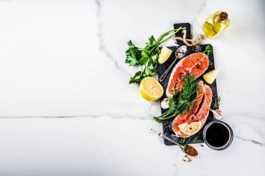 Biftek ile limon, otlar, zeytin yağı, ızgara, kayrak kesme tahtası, beyaz mermer zemin kopya alanı yukarıdaki için hazır çiğ Somon Balık