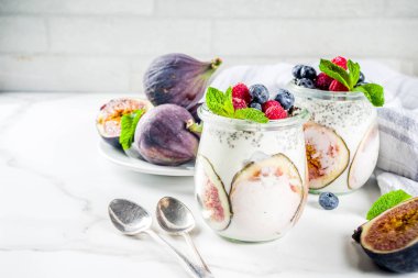 Sağlıklı detoks kahvaltı meze - yoğurt güler yüzlü veya milkshake incir, yaban mersini, ahududu chia tohumu, beyaz mermer zemin, kopya alanı ile