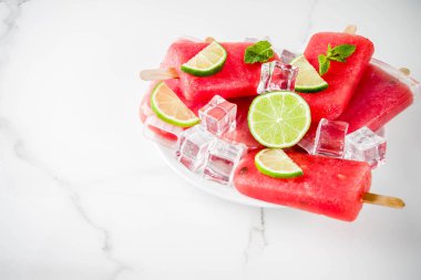Dilimli karpuz ve nane, beyaz mermer zemin kopya alanı ile tatlı yaz karpuz ve kireç popsicles