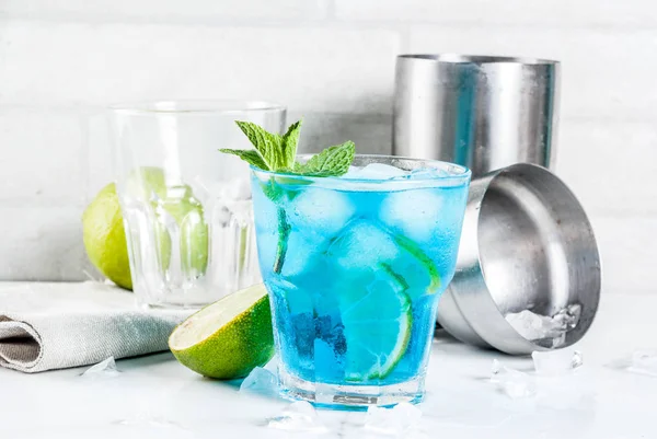 カラフルな夏の飲み物 アイス ライムとミント 白い大理石の背景コピー スペース ブルーラグーン アルコール カクテルを飲む — ストック写真