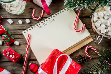 Noel kavramı, xmas tatil için hazırlık için istek listesi, santa harf not etmek. Yapılacaklar listesi için ile sıcak sıcak çikolata Kupası, Noel ağacı dekor, çam dalları. Eski ahşap masa kopya alanı üstten görünüm