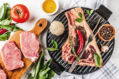 Ham sığır eti striplon kaburga eti domuz biftek baharatlar, ızgara tava ve otlar, beyaz mermer zemin üstten görünüm, kopya alanı ile mermer