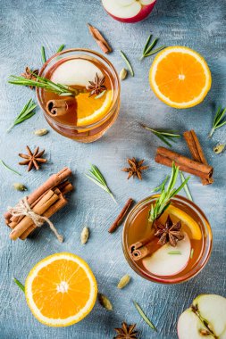 Geleneksel kış içki içer, mulled şarap kokteyli ile baharat, elma, portakal, beyaz şarap. Üzerinde mavi masa lambası,