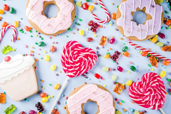 お菓子の創造的なレイアウト キャンディー ゼリー お菓子 クッキー ドーナツやカップケーキ 明るい青の背景平面図コピー スペースとデザートのコンセプト — ストック写真