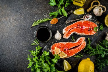 Çiğ Somon Balık biftek ile limon, otlar, zeytin yağı, ızgara, kayrak kesme tahtası, karanlık paslı arka plan kopya alanı için hazır