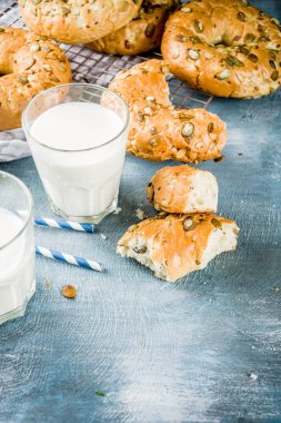 Sağlıklı kahvaltı kavramı, ev yapımı Mısır gevreği simit ile mavi arka plan üzerinde süt cam alanı kopyalayın.