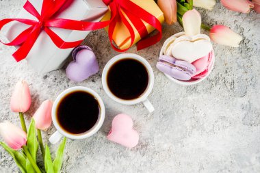 Tebrik kartı Sevgililer tatil için arka plan. Sevgililer günün sunmak, tatlı tedavi. Bir ışık gri beton zemin üzerine Lale çiçek ile ev yapımı pastel renkli macaron tanımlama alanı Kopyala