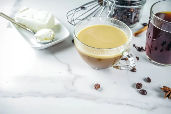 Trendy ketogenic diet food, Bulletproof coffee with milk and butter, white marble background copy space
