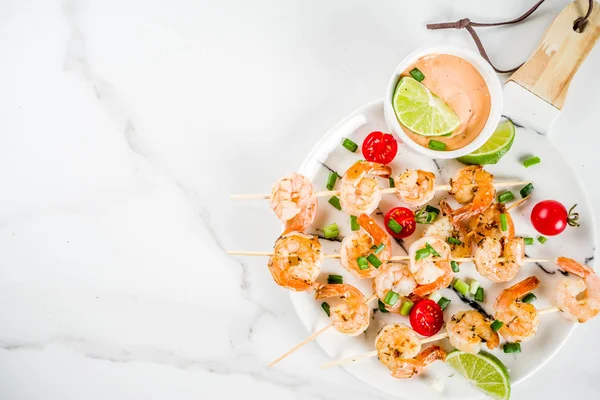 Deniz ürünleri kebap, sos, kireç, soğan ve domates, karides şiş şifreli beyaz mermer arka plan kopya alanı üstten görünüm