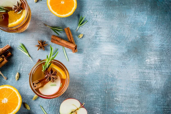 Geleneksel kış içki içer, mulled şarap kokteyli ile baharat, elma, portakal, beyaz şarap. Üzerinde mavi masa lambası,