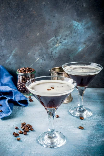 Coffee drink ideas, espresso martini cocktail, two glasses on blue concrete background copy space