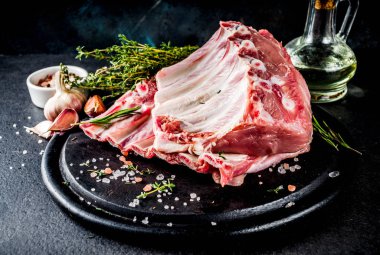 Çiğ et, domuz kaburga otlar ve baharatlar, siyah taş zemin alanı kopyalayın.