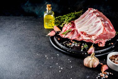 Çiğ et, domuz kaburga otlar ve baharatlar, siyah taş zemin alanı kopyalayın.