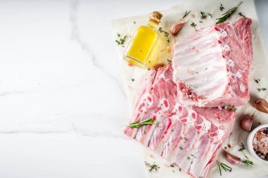 Çiğ et, domuz kaburga otlar ve baharatlar, beyaz mermer zemin ile alanı kopyalayın.