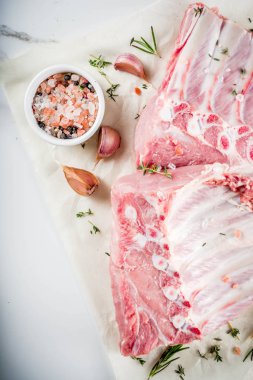 Çiğ et, domuz kaburga otlar ve baharatlar, beyaz mermer zemin ile alanı kopyalayın.