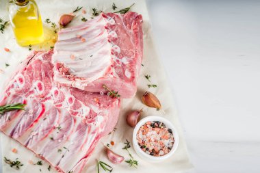 Çiğ et, domuz kaburga otlar ve baharatlar, beyaz mermer zemin ile alanı kopyalayın.