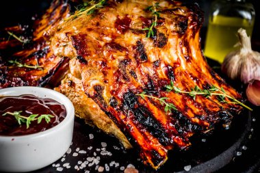 Izgara et kavramı. Barbekü domuz kaburga Barbekü sosu, zeytin yağı ile. koyu ahşap arka plan kopya alanı üzerinde taze otlar