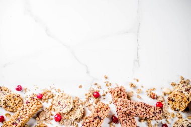 Çok tahıl granola müsli bar. Sağlıklı yiyecek, kurutulmuş meyveler, fındık, tahıl ve bal ile diyet snack. Bir beyaz mermer zemin, üstten görünüm Kopyala yer metin için.