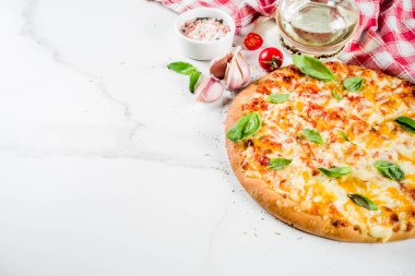 Ev yapımı dilimlenmiş peynirli klasik İtalyan pizza malzemeleri ve zeytinyağı, beyaz mermer zemin kopya alanı üstten görünüm