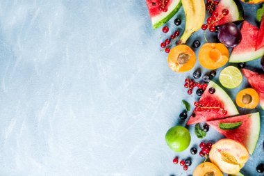 Yaz vitamin gıda kavramı, çeşitli meyve ve çilek karpuz şeftali nane erik kayısı yaban mersini frenk üzümü, açık mavi renkli üstten görünüm kopya alanı üzerinde yaratıcı düz lay