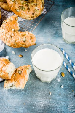 Sağlıklı kahvaltı kavramı, ev yapımı Mısır gevreği simit ile mavi arka plan üzerinde süt cam alanı kopyalayın.