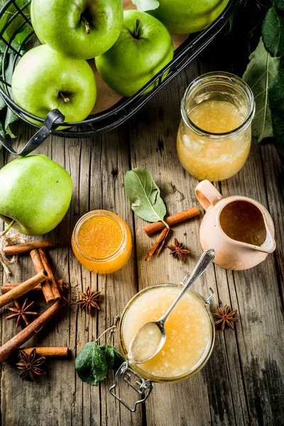 Homemade apple jam or sauce, with green apples and spices, wooden rustic background copy space