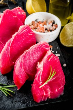 Taze çiğ ton balığı biftek yemek, malzemeler siyah taş arka plan ile uzay üstten görünüm Kopyala