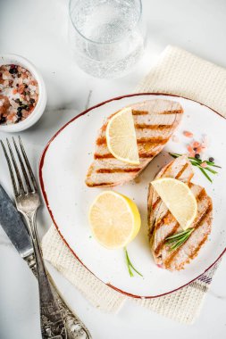 Limon ve baharatlar, alakart plaka, beyaz mermer zemin kopya alanı üstten görünüm üzerinde ton balığı biftek ızgara