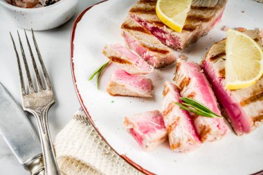 Limon ve baharatlar, alakart plaka, beyaz mermer zemin kopya alanı üstten görünüm üzerinde ton balığı biftek ızgara