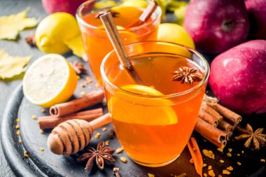 Sonbahar Kış iki bardak sıcak kırmızı elma, limon, tarçın, anason, tatlım, karanlık paslı arka plan kopya alanı ile baharatlı çay