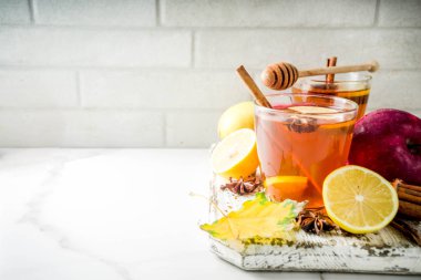 Kırmızı elma, limon, tarçın, anason, tatlım, beyaz mermer zemin ile sonbahar kış sıcak baharatlı çay iki bardak alanı Kopyala