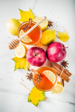 Kırmızı elma, limon, tarçın, anason, tatlım, beyaz mermer zemin ile sonbahar kış sıcak baharatlı çay iki bardak alanı Kopyala