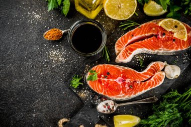 Çiğ Somon Balık biftek ile limon, otlar, zeytin yağı, ızgara, kayrak kesme tahtası, karanlık paslı arka plan kopya alanı için hazır