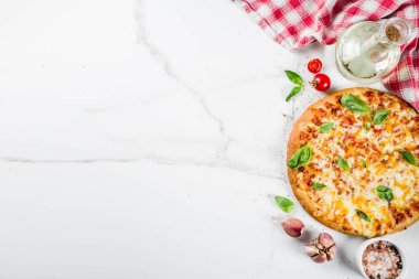 Ev yapımı dilimlenmiş peynirli klasik İtalyan pizza malzemeleri ve zeytinyağı, beyaz mermer zemin kopya alanı üstten görünüm