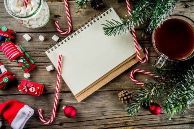 Noel kavramı, xmas tatil için hazırlık için istek listesi, santa harf not etmek. Yapılacaklar listesi için ile sıcak sıcak çikolata Kupası, Noel ağacı dekor, çam dalları. Eski ahşap masa kopya alanı üstten görünüm