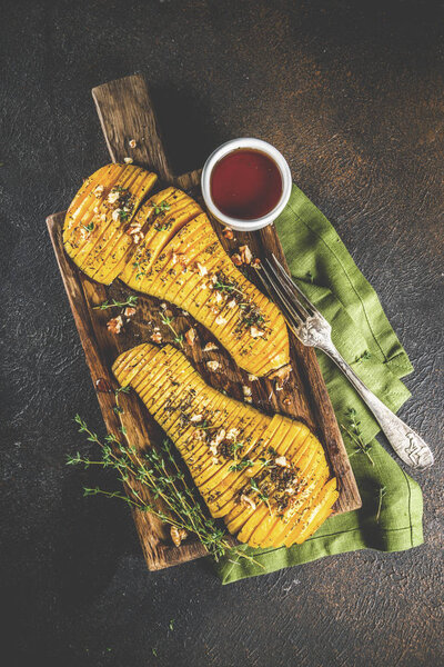 Simple autumn domestic recipes, roasted hasselback butternut squash pumpkin with thyme, honey and maple syrup,