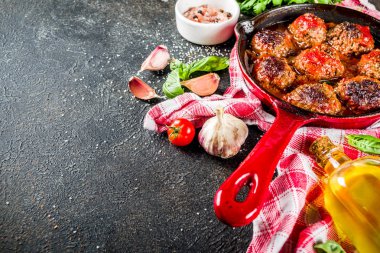 Karanlık paslı taş masada küçük tavada domates soslu ev yapımı Fırında köfte. Üstten görünüm kopya alanı