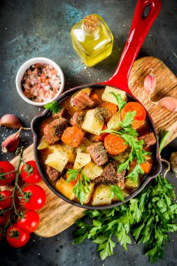 Ev yapımı sığır eti güveç, patates, havuç ve otlar üstünde koyu arka plan üstten görünüm Kopyala yer Macar gulaş