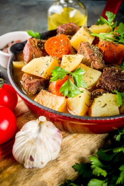 Ev yapımı sığır eti güveç, patates, havuç ve otlar üstünde koyu arka plan üstten görünüm Kopyala yer Macar gulaş