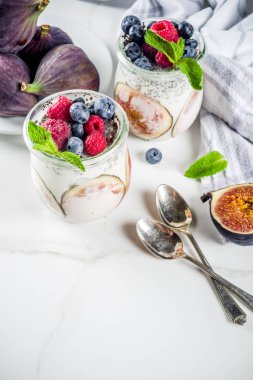 Sağlıklı detoks kahvaltı meze - yoğurt güler yüzlü veya milkshake incir, yaban mersini, ahududu chia tohumu, beyaz mermer zemin, kopya alanı ile