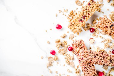 Çok tahıl granola müsli bar. Sağlıklı yiyecek, kurutulmuş meyveler, fındık, tahıl ve bal ile diyet snack. Bir beyaz mermer zemin, üstten görünüm Kopyala yer metin için.