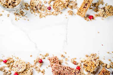 Çok tahıl granola müsli bar. Sağlıklı yiyecek, kurutulmuş meyveler, fındık, tahıl ve bal ile diyet snack. Bir beyaz mermer zemin, üstten görünüm Kopyala yer metin için.