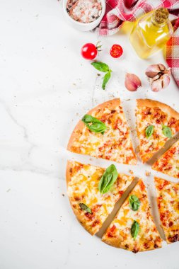 Ev yapımı dilimlenmiş peynirli klasik İtalyan pizza malzemeleri ve zeytinyağı, beyaz mermer zemin kopya alanı üstten görünüm