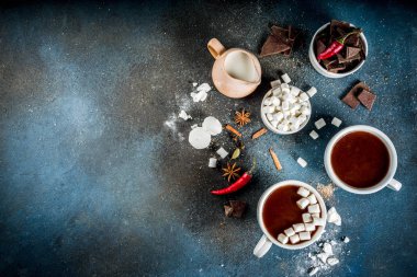 Sıcak çikolata bardak, çikolata, şeker, lokum, kırmızı biber ve baharat adet kırık. Koyu mavi beton arka plan üstten görünüm alanı