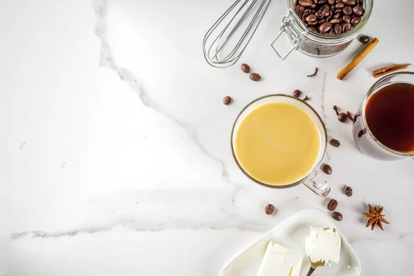 Trendy ketogenic diet food, Bulletproof coffee with milk and butter, white marble background copy space top view