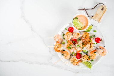 Deniz ürünleri kebap, sos, kireç, soğan ve domates, karides şiş şifreli beyaz mermer arka plan kopya alanı üstten görünüm