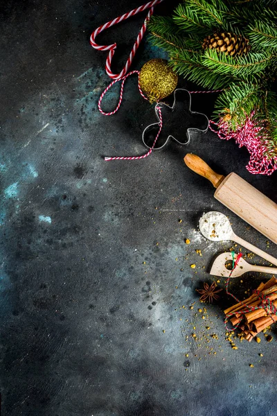 Christmas bakery background, with baking utensils, flour, spices and decorations, dark concrete table, copy space top view