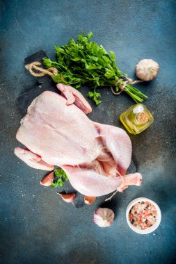 Tavuk arka plan bütün tavuk, otlar ve baharatlar, koyu mavi beton tablo kopya alanı üstten görünüm ile pişirme