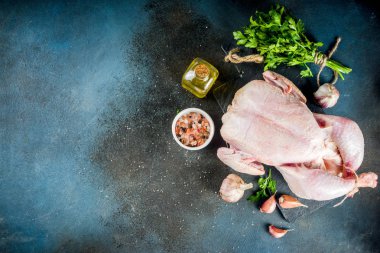 Tavuk arka plan bütün tavuk, otlar ve baharatlar, koyu mavi beton tablo kopya alanı üstten görünüm ile pişirme